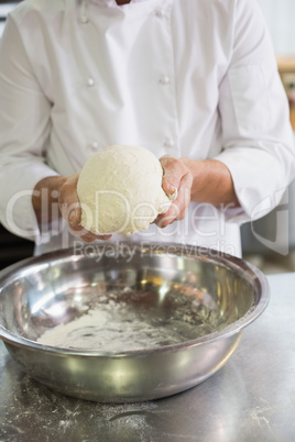 Baker forming dough in mixing bowl