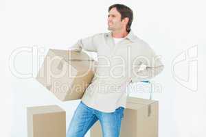 Delivery man with cardboard box suffering from back ache