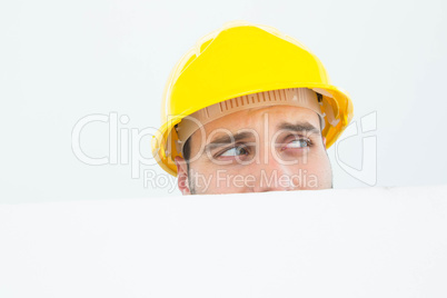 Repairman looking away while in front of billboard