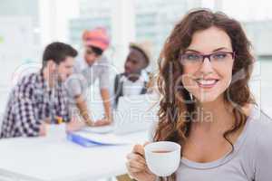 Smiling businesswoman holding cup of coffee