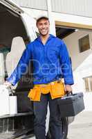 Smiling handsome handyman holding toolbox