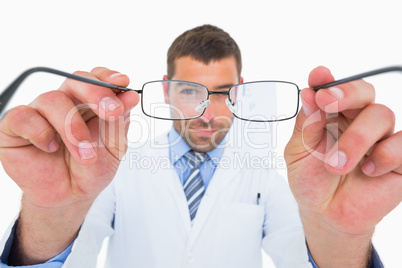Smiling optician presenting eyeglasses