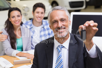 Smiling businessman showing a car key