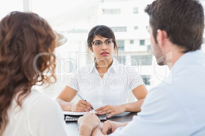 Therapist listening her patients and taking notes