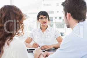 Therapist listening her patients and taking notes