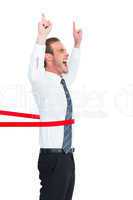 Happy businessman crossing the finish line and pointing up