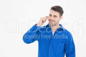 Happy young male mechanic using mobile phone