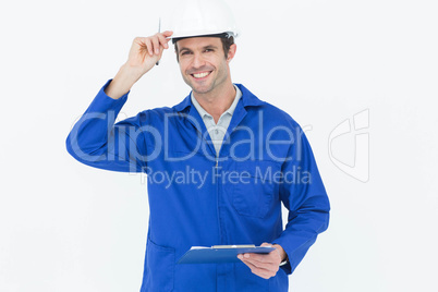 Happy supervisor wearing hard hat while holding clip board