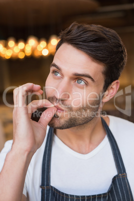 Handsome waiter making tasty gesture