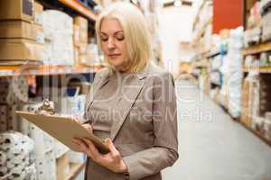 Focused female manager holding clipboard