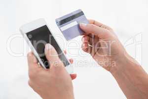 Hands of woman holding smartphone and credit card