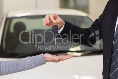 Smiling businessman giving car key to happy customer