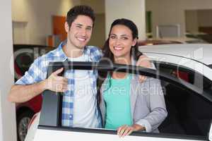 Smiling couple in a car shop