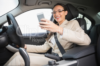 Smiling businesswoman sending a text message