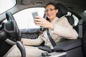 Smiling businesswoman sending a text message