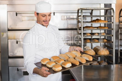 Happy baker showing tray of fresh bread