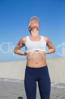 Fit blonde touching her back on the pier