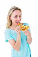 Cheerful blonde eating slice of pizza