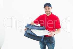 Delivery man removing pizza box from bag
