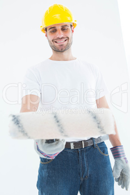 Man wearing helmet while using paint roller