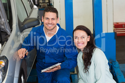 Mechanic and customer smiling at camera