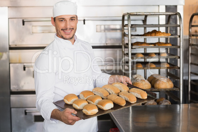 Happy baker showing tray of fresh bread Happy baker showing tray of fresh bread