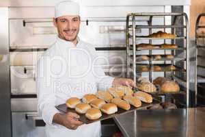 Happy baker showing tray of fresh bread