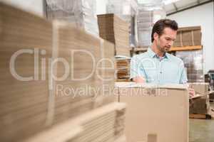 Warehouse worker checking his list on clipboard