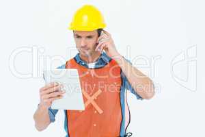 Carpenter using digital tablet and mobile phone