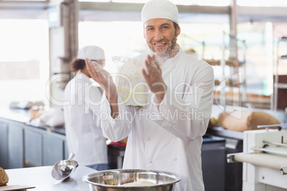 Baker clapping flour from his hands