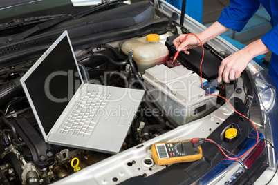 Mechanic using diagnostic tool on engine