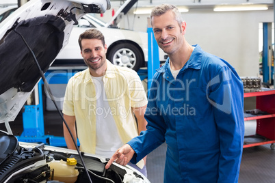 Mechanic showing customer the problem with car