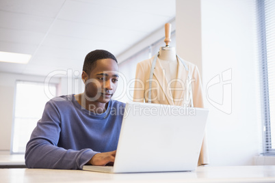 Smiling university student using laptop