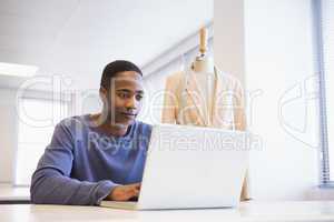 Smiling university student using laptop