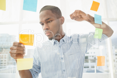 Focused businessman reading sticky notes