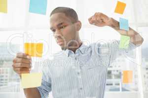 Focused businessman reading sticky notes