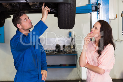 Mechanic showing customer the problem with car