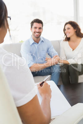 Smiling couple speaking with their therapist