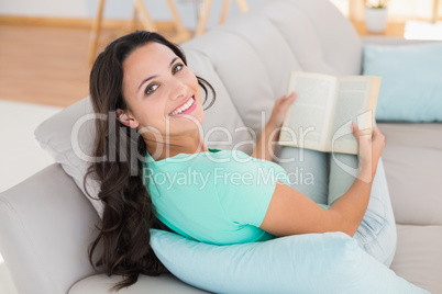 Woman reading book on couch