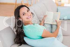 Woman reading book on couch