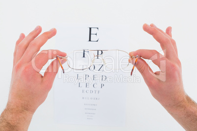 Hands holding glasses for eye test