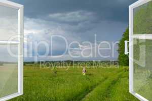 opened window to summer field before thunder