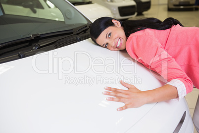 Smiling woman hugging a white car