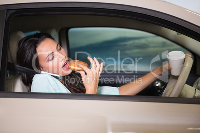 Woman drinking coffee and eating donnut on phone
