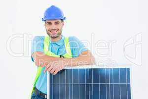 Happy worker leaning on solar panel