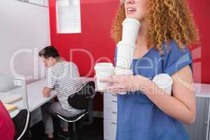 Student holding pile of coffee cup near classmate