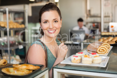 Pretty brunette looking at cakes