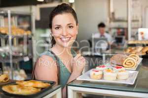 Pretty brunette looking at cakes