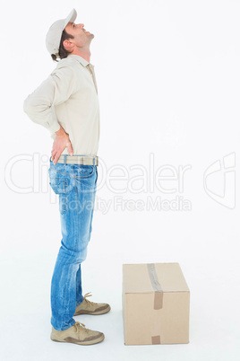 Delivery man suffering from back pain standing by box