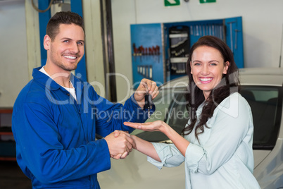 Mechanic and customer smiling at camera